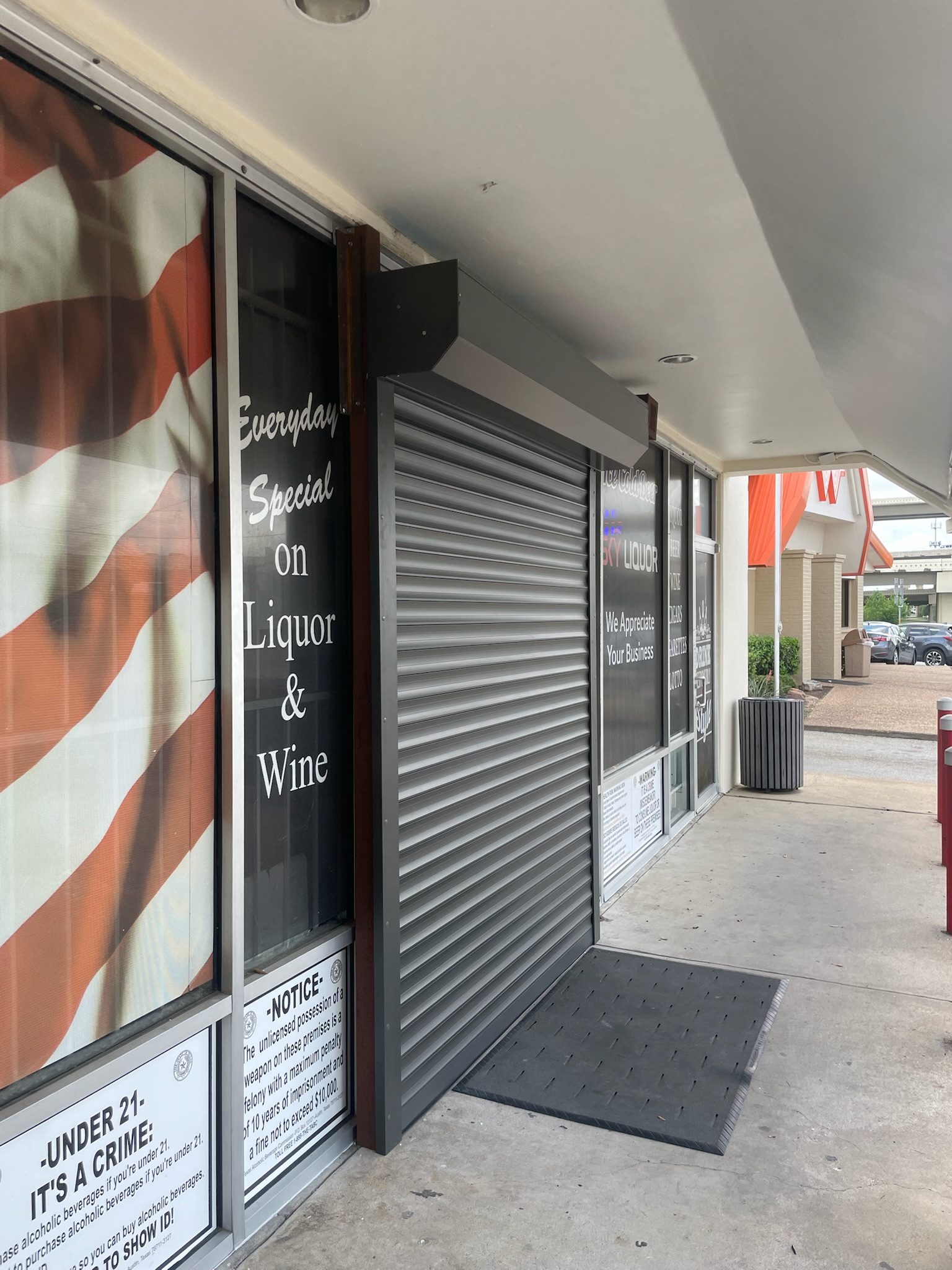 Silver roll-down shutter at liquor store entrance