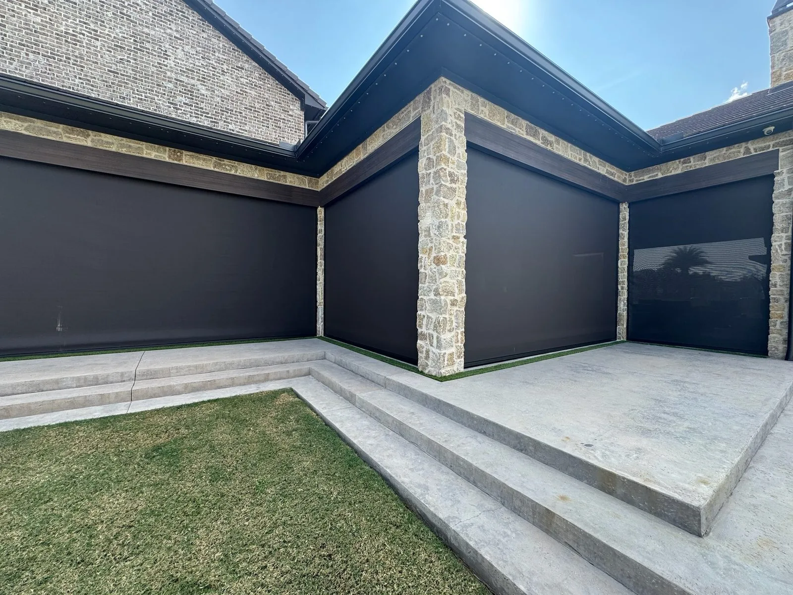 Full-covering exterior shades on stone home corner