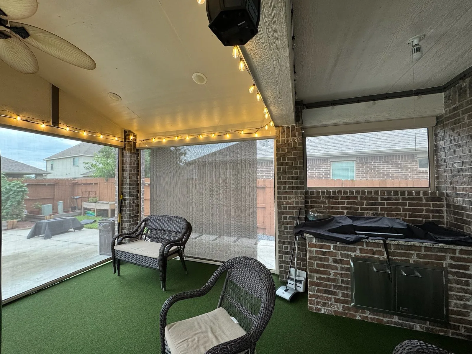 Covered suburban patio with drop shades and outdoor furniture